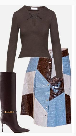 A fashion outfit consisting of a dark brown long-sleeve knit top with a keyhole cutout, a patchwork skirt with blue, brown, and beige panels, and a tall dark brown heeled boot with a gold chain detail, set against a plain white background.