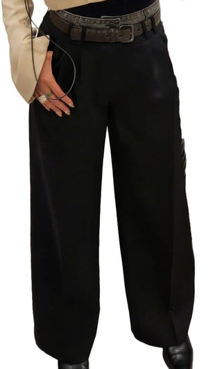 A person wearing black wide-leg trousers with a dark gray textured waistband and a wide brown belt, paired with a beige jacket and black pointed shoes.