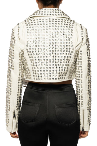 A cropped off-white leather jacket covered in silver studs, shown from the back on a model wearing black pants against a white background.